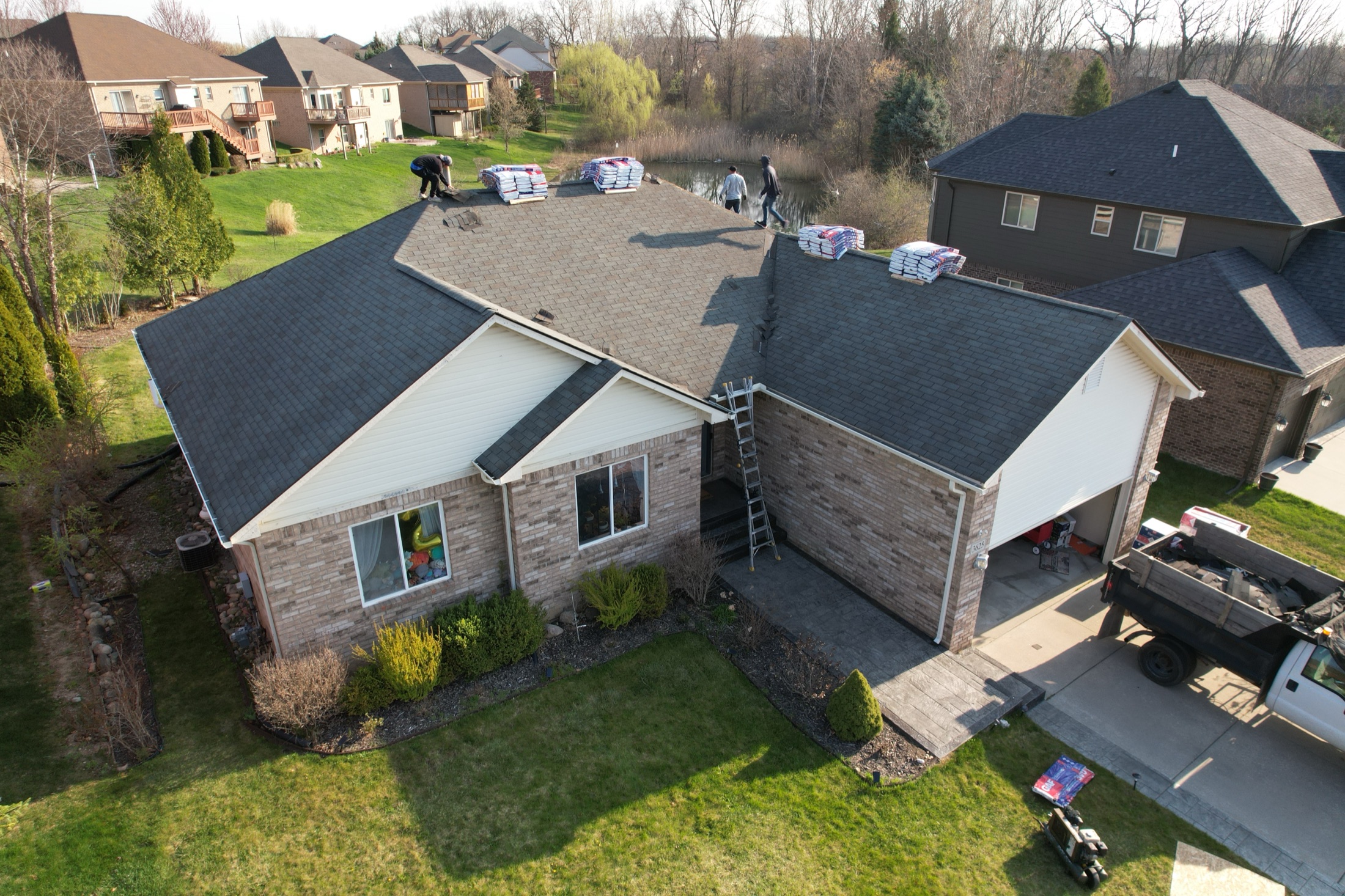 Ambia Roofing crew reviewing a residential roof from above